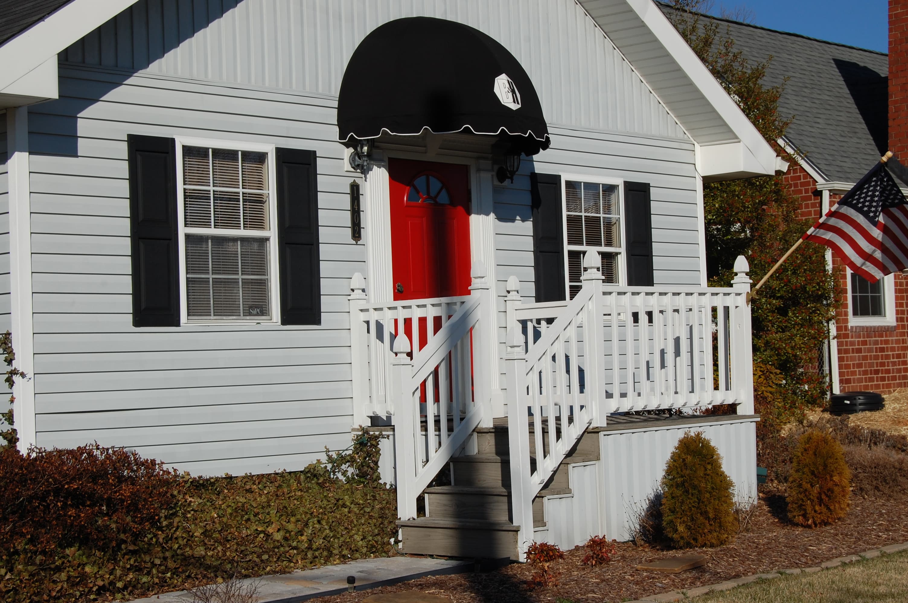 The front door of the B&H office at 1402, under a black awning with the B&H logo.