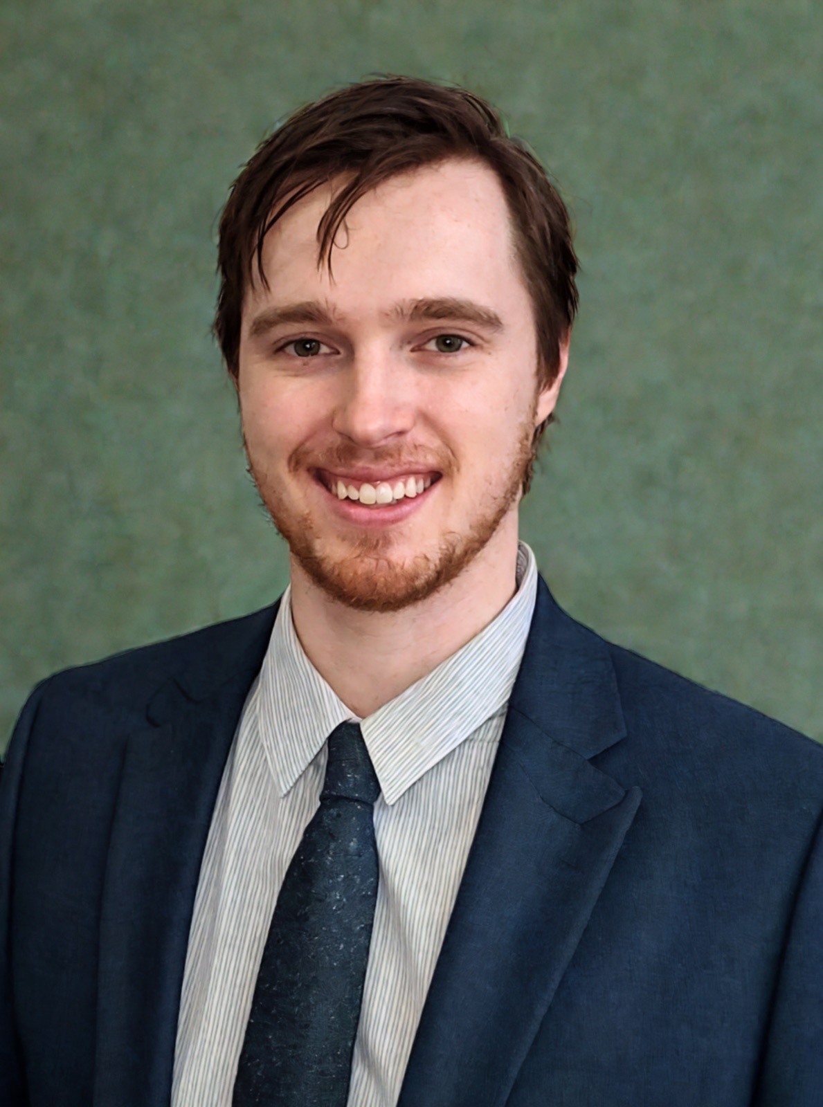 Jake Bingham, smiling in a navy suit and dark tie