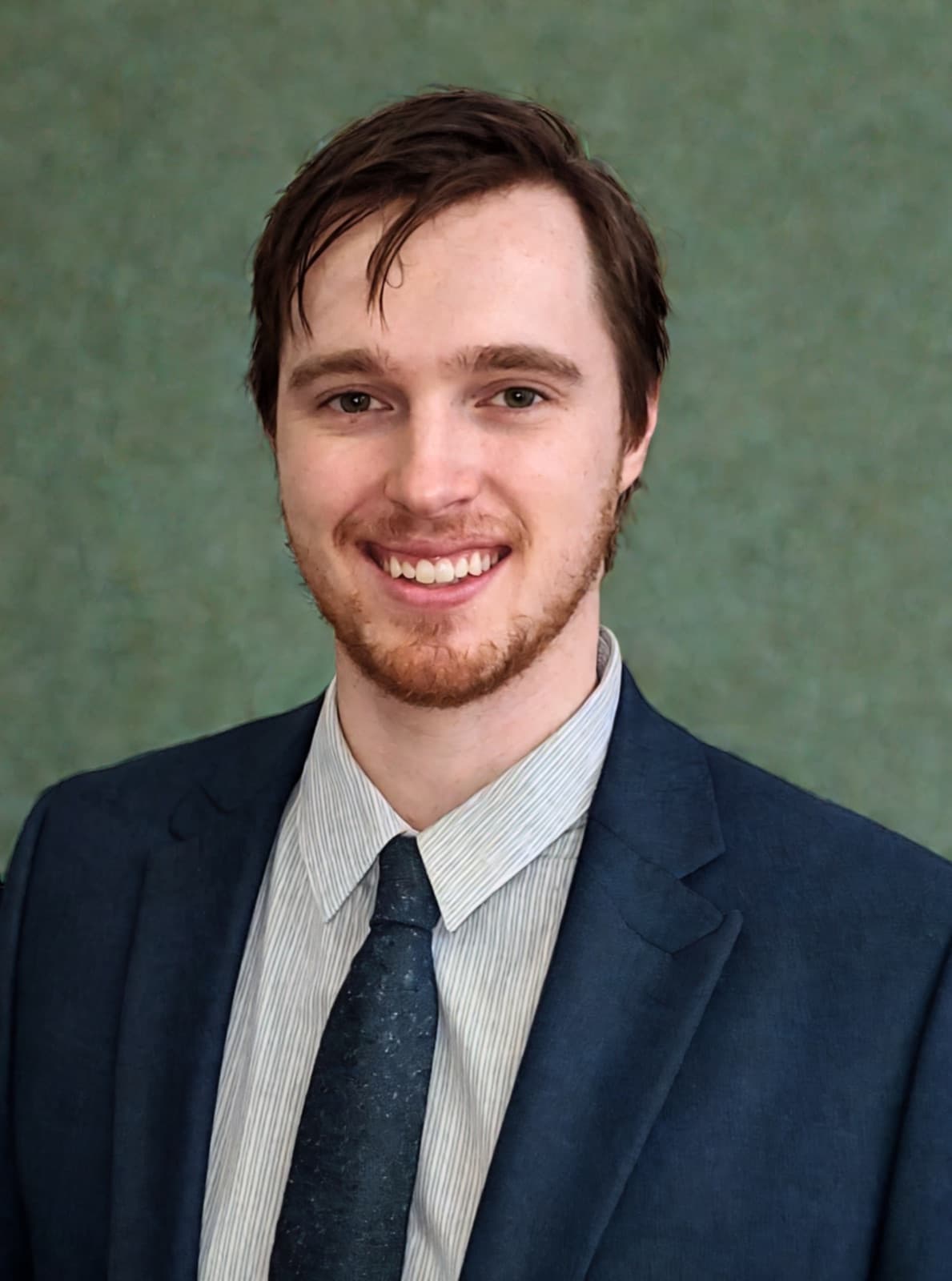 Jake Bingham, smiling in a navy suit and dark tie