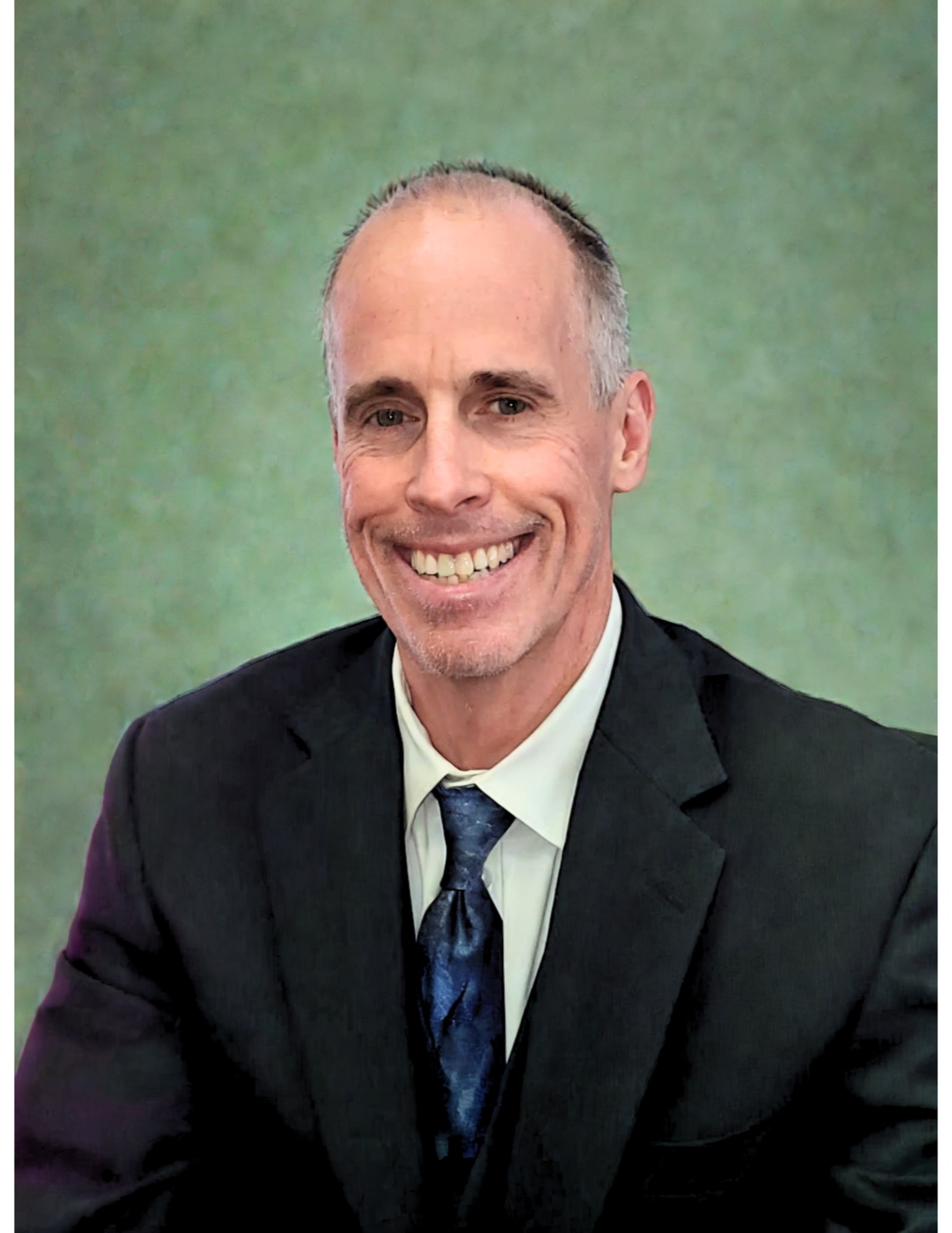 Jeff Bingham, smiling in a dark suit and blue tie