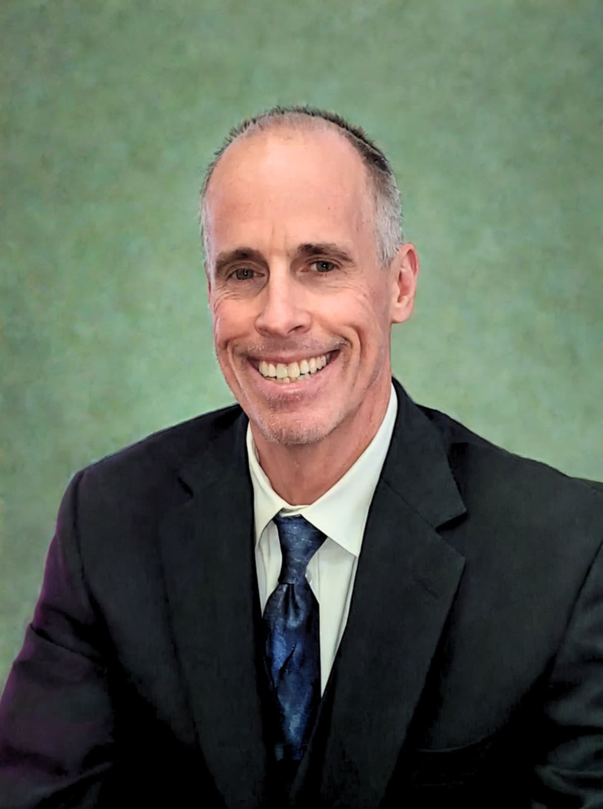 Jeff Bingham, smiling in a dark suit and blue tie